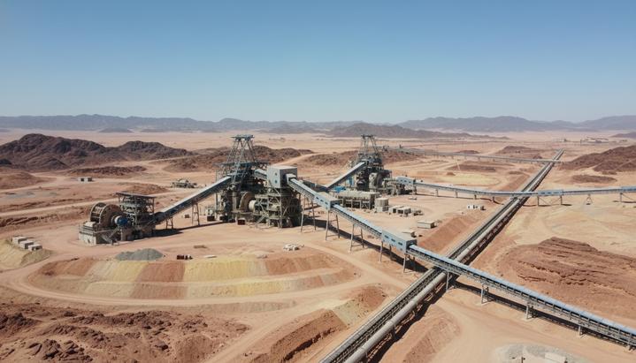 Современное горнодобывающее предприятие с технологичным оборудованием и трубопроводами в скалистой пустыне Саудовской Аравии.